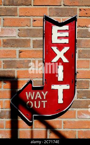 red exit, way out sign on brick wall background Stock Photo