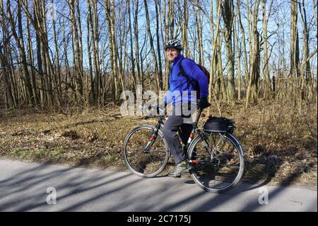 Kaliningrad, Russia, March 15, 2020. A man in a helmet on a Bicycle. A cyclist in a blue jacket. Stock Photo