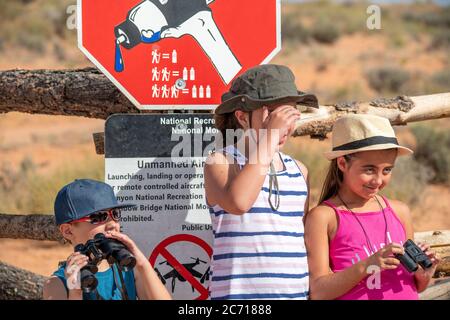 Three children wearing hats at the entrance of a national park in summer season. Stock Photo