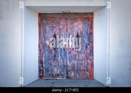 Old and rusty door, entrance to an old abandoned building Stock Photo