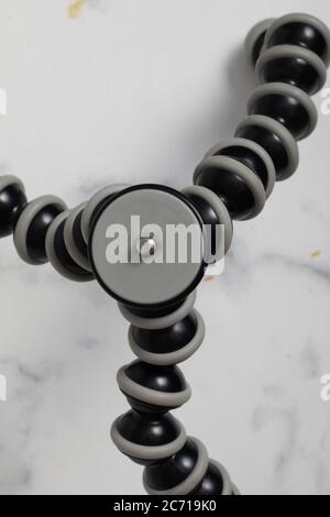Black tripod isolated on a white background. Mini tripod for the phone. Camera support. Desktop tripod. Mobile tripod. Stock Photo