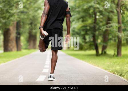 Health, fitness and black man stretching legs outdoors on city