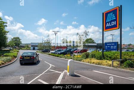 Aldi Supermarket. A car entering the supermarket retailer, Aldi, on a bright day in the East Sussex town of Eastbourne, England. Stock Photo