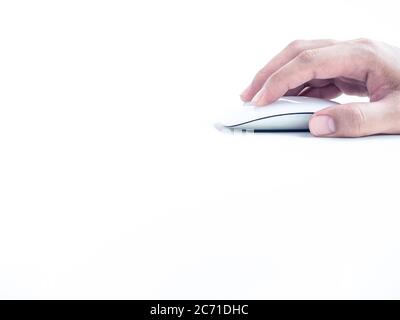 Hand using computer mouse. Finger clicking on white modern mouse isolated on white background with copy space. Stock Photo