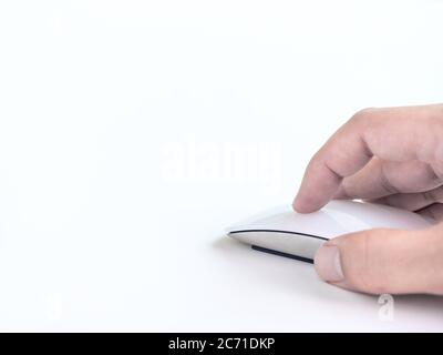 Hand using computer mouse. Finger clicking on white modern mouse isolated on white background with copy space. Stock Photo