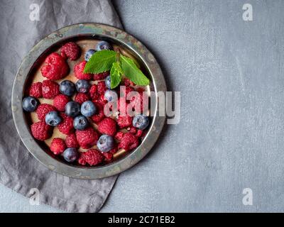 Blueberries and raspberries on plate. A mix of berries on dark background, copy space. Stock Photo