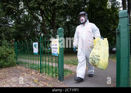 A worker for Leicester City Council carries a bag of clinical waste away from a Covid-19 testing station at Spinney Hill Park in Leicester where localised coronavirus lockdown restrictions have been in place since June 29, with non-essential shops ordered to close and people urged not to travel in or out of the area. Stock Photo