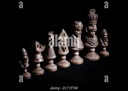 chess pieces in a row on a black background