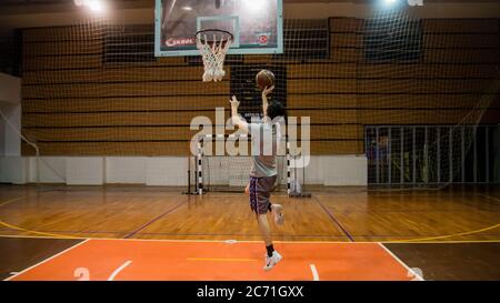 Antalya - Turkey - October 17, 2013: Young man practicing basketball alone in arena