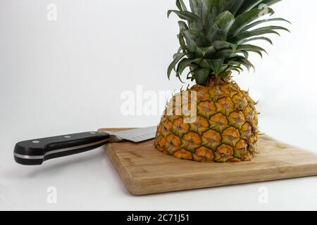 pineapple cut in half with knife Stock Photo