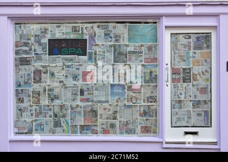 Closed down Nails & Spa bar, salon with Windows covered in Newspaper Hastings, East Sussex, England, UK Stock Photo