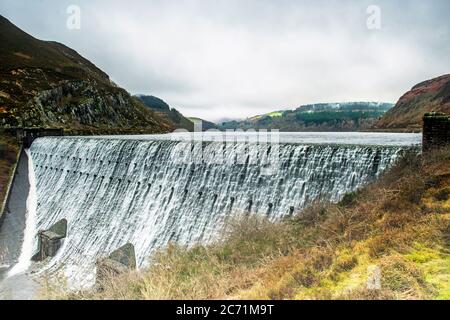 Water cascading over the top of the Caban Coch Dam in the Elan Valley, Powys, Mid Wales.. Stock Photo