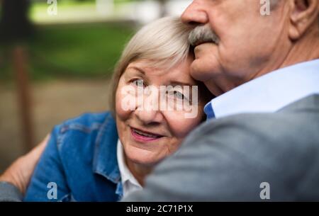 Happy senior couple in love sitting outdoors, midsection. Stock Photo