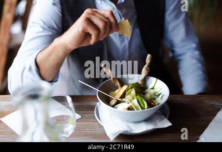 Unrecognizable man sitting indoors in restaurant, eating. Stock Photo