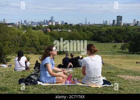People enjoy the warm weather on Parliament Hill in London. Stock Photo