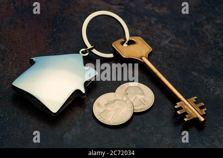 key with house shape trinket laying on dark background Stock Photo