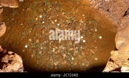 Mira de Aire, Portugal, April 2018: Wishing well and coins inside Grutas Mira de Aire cave in Portugal Stock Photo