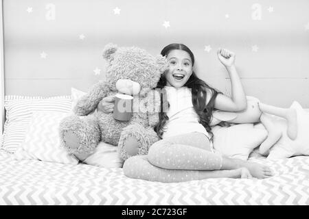 Little child hold mug. Girl in pajamas drinking tea. Relaxation before sleep. Drinking milk just before bed. Bedtime beverage. Hot milk before sleep. Health Benefits Drinking water before bed. Stock Photo