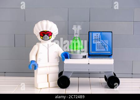 Tambov, Russian Federation - June 08, 2020 Lego scientist minifigure in protective suit near his working place against gray wall. Stock Photo