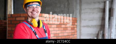 Smiling builder writing on clipboard work results Stock Photo