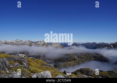 On top of mountains in Fjordland National Park - Doubtful Sound - clouds Stock Photo