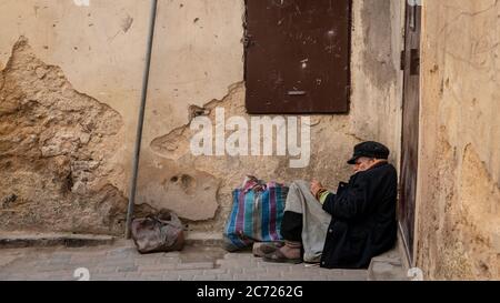 Fez, Morocco - April 2018: Anonymous poor beggar in the street of Fez, Morocco. Stock Photo