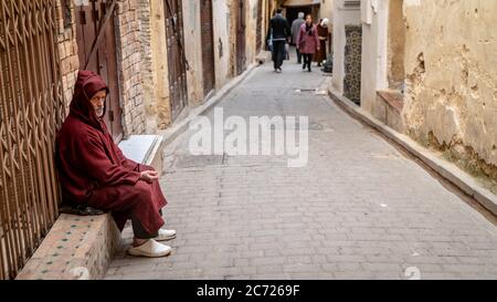 Fez, Morocco - April 2018: Anonymous poor beggar in the street of Fez, Morocco. Stock Photo