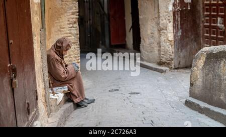 Fez, Morocco - April 2018: Anonymous poor beggar in the street of Fez, Morocco. Stock Photo