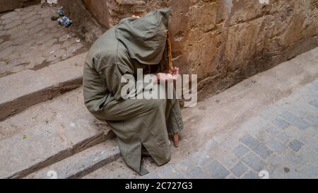 Fez, Morocco - April 2018: Anonymous poor beggar in the street of Fez, Morocco. Stock Photo