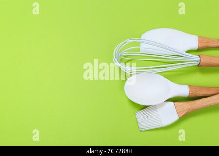 https://l450v.alamy.com/450v/2c7288h/set-of-kitchen-utensils-with-wooden-handles-on-a-green-background-2c7288h.jpg