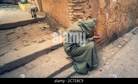 Fez, Morocco - April 2018: Anonymous poor beggar in the street of Fez, Morocco. Stock Photo