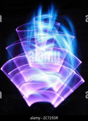Curved and flame shape made of led light and white streaks made to optical fiber at lightpainting. Stock Photo