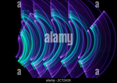 Curved abstract shape made with a light saber violet. Lightpainting session at night. Leds light effect. Stock Photo