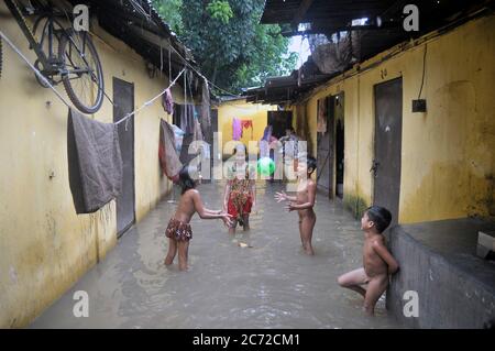Children are playing in flood water. The area of Teroroton is submerged with water due the recent floods from the heavy rainfall triggered during the monsoon season over the last few days. Bangladesh is also heavily hit by the coronavirus pandemic. Sylhet, Bangladesh. Stock Photo