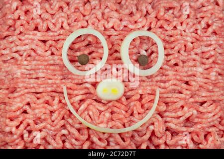 Minced meat with face made of onions and allspice Stock Photo