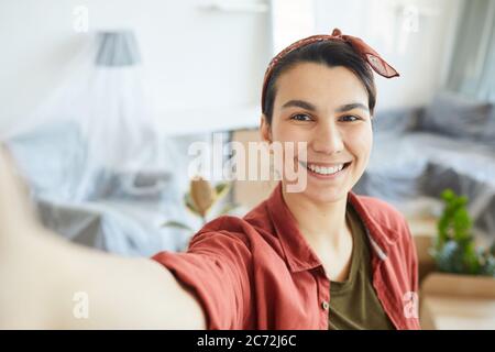 Portrait of happy young woman making selfie portrait at home Stock Photo