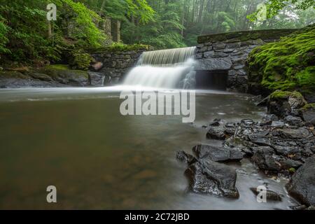 Beautiful waterfall at Black River Park in NJ featuring ruins of old cottage on the background Stock Photo