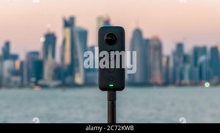 Doha, Qatar - February 2019: Insta360 One X 360 camera on a tripod with cityscape in the background Stock Photo