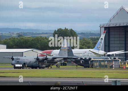 Prestwick, Scotland, UK. 13th July, 2020. Pictured: (left) A Canadian Air Force C130 Hercules Aircraft (reg 130616) seen departing Prestwick Airport. It had landed an hour earlier and looks like this was a refuelling stop for the crew; (right) A US Air Force C130 Hercules Aircraft (Reg 56709) sit on the tarmac by the Ryanair Hanger. Credit: Colin Fisher/Alamy Live News Stock Photo