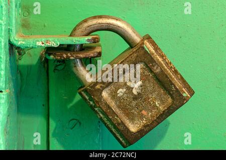 Locked old iron padlock on a green door. Close-up Stock Photo