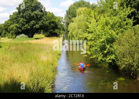 Viersen, Germany - July 9. 2020: View on river Niers in green idyllic landscape with trees and people paddle canoes on boat tour Stock Photo