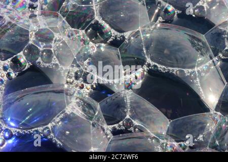 Bubbles on top of blue water with texture an macro close up. Stock Photo