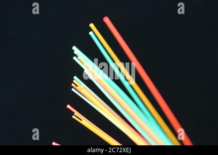 Close up macro of a colorful group of  fiber optics on a black background. Stock Photo