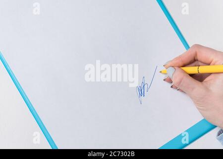 Woman's hand puts his signature on sheet of paper. Sign in document. Close up, copy space, backdrop pattern. Stock Photo