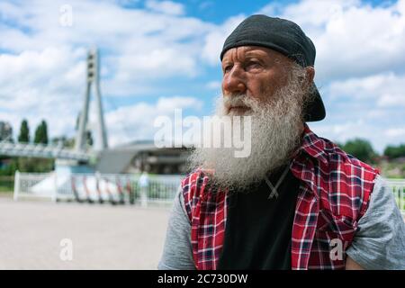 Stylish old man with grey beard outdoors Thoughts on the life of a hipster Stock Photo
