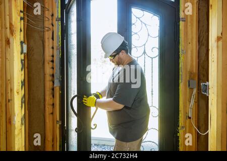 Builder in installing a door lock the door of a new house hand close-up. Stock Photo