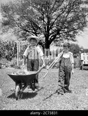 1930s TWO YOUNG SMILING FARM BOYS BROTHERS WEARING OVERALLS WALKING TOGETHER TOWARD CAMERA WITH WHEELBARROW AND GARDENING TOOLS  - f6904 HAR001 HARS PLEASED JOY LIFESTYLE BROTHERS JOBS RURAL HEALTHINESS HOME LIFE COPY SPACE FRIENDSHIP FULL-LENGTH OVERALLS CARING FARMING MALES SIBLINGS WHEELBARROW CONFIDENCE AGRICULTURE B&W GOALS HAPPINESS WELLNESS CHEERFUL STRENGTH STRATEGY AND FARMERS LEADERSHIP TOWARD PRIDE OPPORTUNITY SIBLING SMILES TASKS CONNECTION CONCEPTUAL STRAW HAT JOYFUL STYLISH VARIOUS BLUE JEANS COOPERATION GROWTH JUVENILES TOGETHERNESS BLACK AND WHITE CAUCASIAN ETHNICITY HAR001 Stock Photo