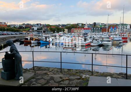 Torshavn harbor at dusk with the female statue in honor of the processing of cod in foreground.Torshavn. Streyomy. Faroe Islands.Territory of Denmark Stock Photo