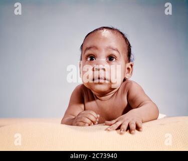 1960s WIDE-EYED STARTLED SURPRISED AFRICAN-AMERICAN BABY BOY PORTRAIT EAGER FACIAL EXPRESSION CRAWLING ON COTTON SUMMER BLANKET - kn731 HAR001 HARS LIFESTYLE STUDIO SHOT HEALTHINESS HOME LIFE COPY SPACE HALF-LENGTH MALES CRAWLING EYE CONTACT HEAD AND SHOULDERS CHEERFUL DISCOVERY AFRICAN-AMERICANS AFRICAN-AMERICAN EXCITEMENT LOW ANGLE PROGRESS BLACK ETHNICITY PRIDE ON SMILES CONCEPTUAL CURIOUS JOYFUL STYLISH BABY BOY WIDE-EYED CHARMING EAGER ENERGETIC GROWTH JUVENILES STARTLED EXPLORING HAR001 INQUISITIVE OLD FASHIONED AFRICAN AMERICANS Stock Photo