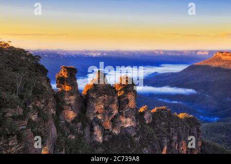 Peaks of three sisters rock formation in the Blue Mountains of Australia at sunrise from Echo point. Stock Photo